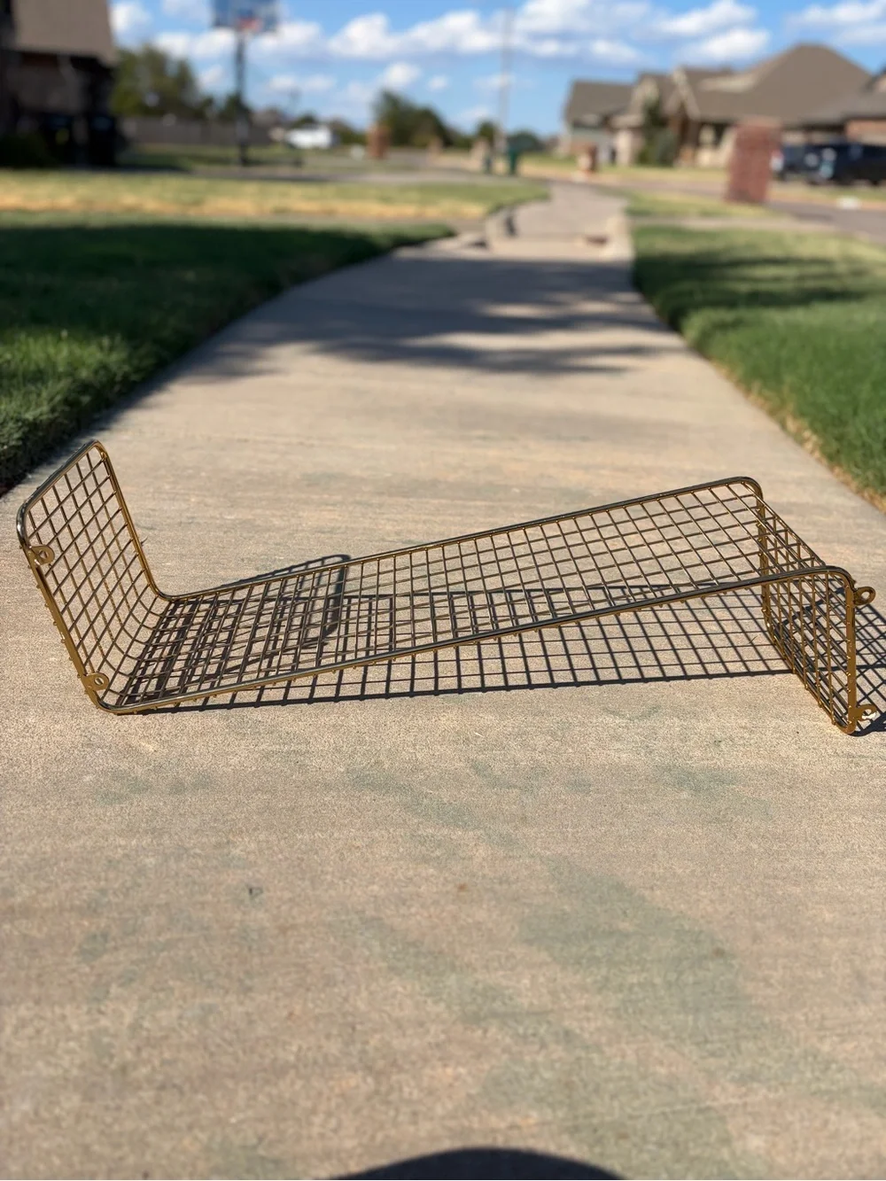 IKEA Svenshult gold-finished wire mesh wall shelf.